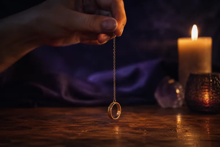 Pendule improvisé fabriqué avec une bague suspendue à une chaîne fine